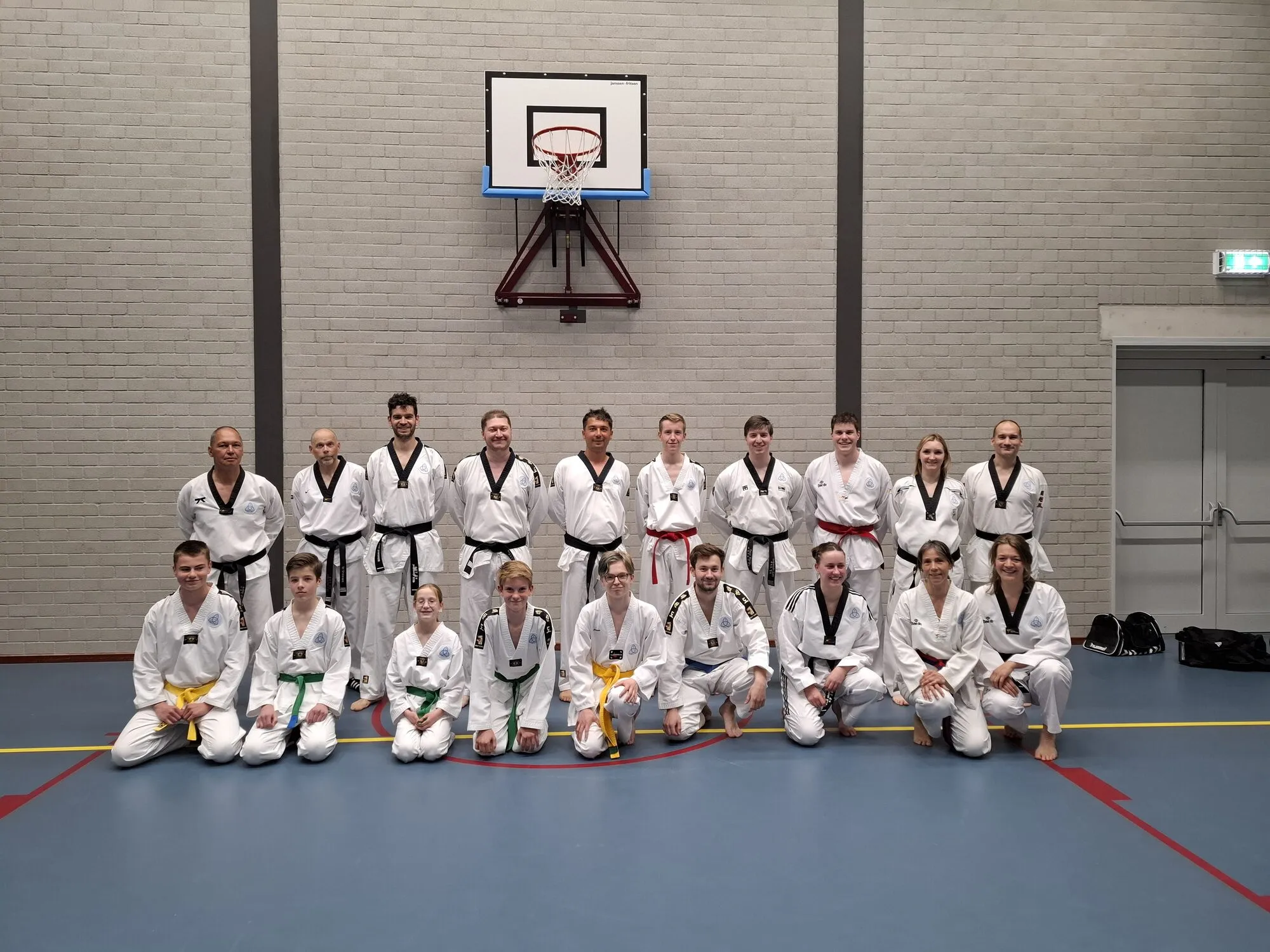 Leden van Ilyo, jong en oud, poseren samen in de gymzaal