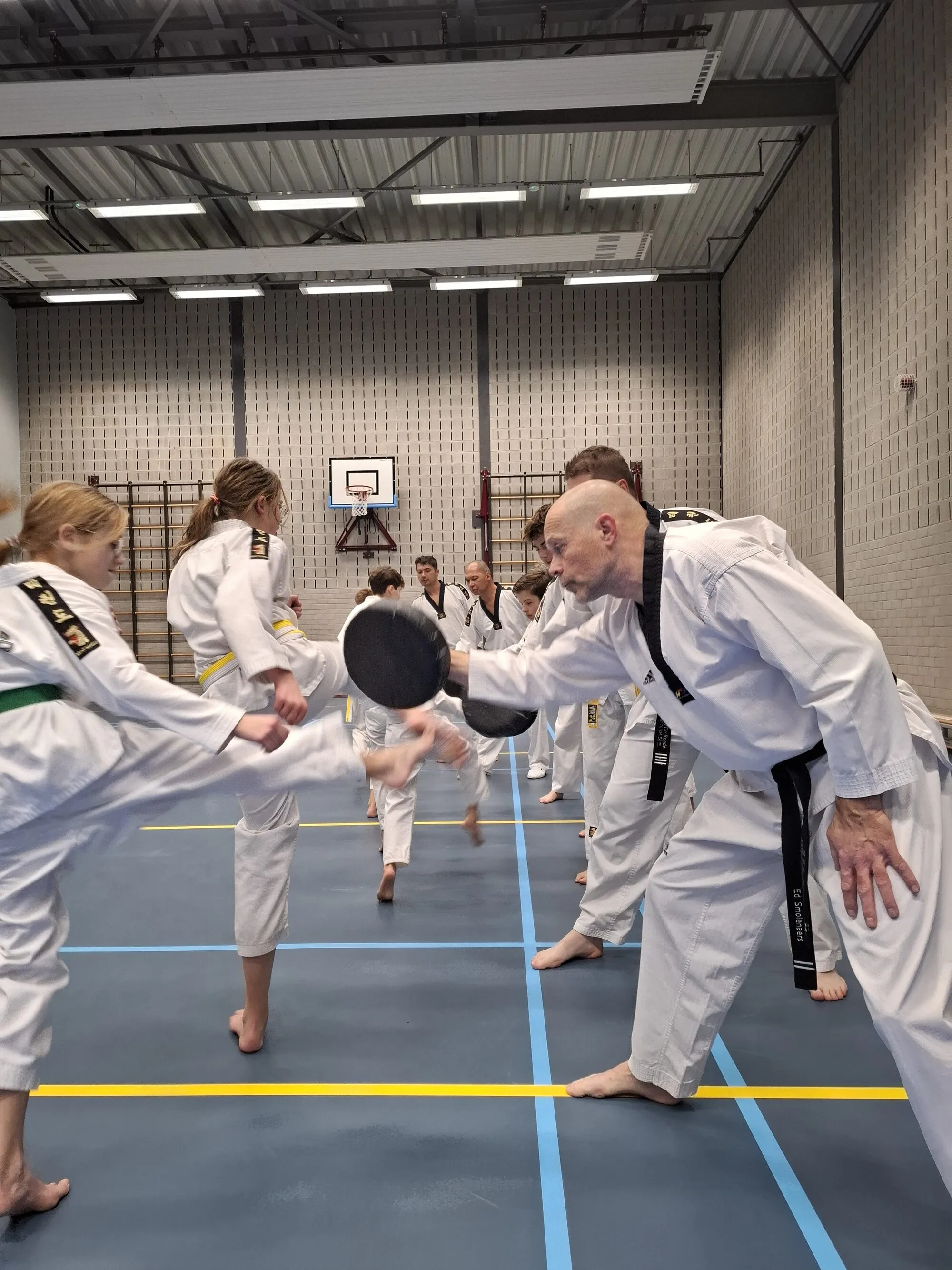 Leden oefenen trappen op een trappad dat de trainer vasthoudt